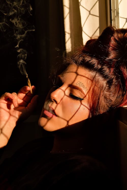 Free A Woman Smoking a Cigarette Stock Photo