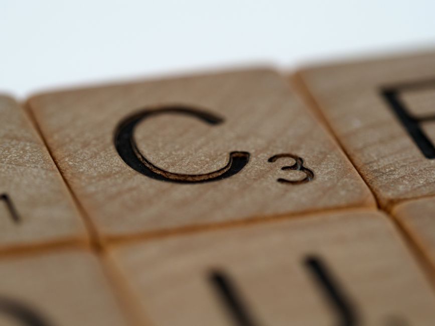 Macro shot highlighting the wooden texture and letter C on a Scrabble tile.