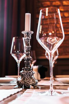 Sophisticated table setup with a candle holder and wine glasses on display.