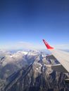 White and Red Airplane Wing over the Mountains