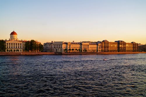 Free Scenic view of St. Petersburg's waterfront buildings during sunset along the Neva River. Stock Photo