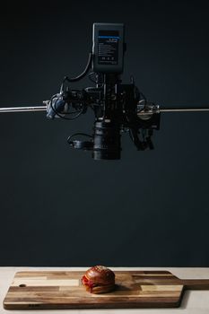 Overhead camera captures a gourmet burger on a cutting board in a studio.