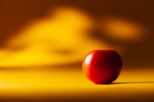 Red Cherry Tomato on Yellow Surface