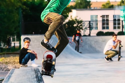 Free Young skateboarder performing a trick at an urban skatepark on a sunny day. Stock Photo