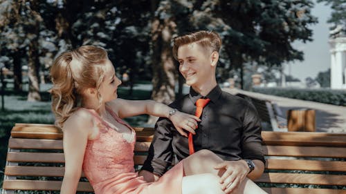Free A Happy Young Couple Sitting on a Bench Stock Photo