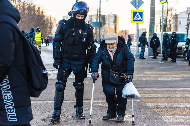 Police Man Helping An Old Woman 