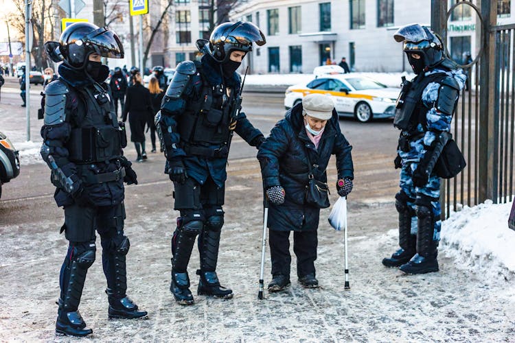 Riot Police Helping An Elderly Person Cross The Street