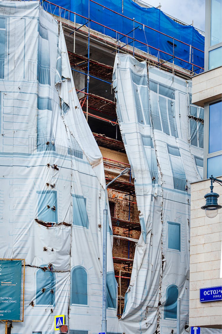 Construction Equipment Hidden Under Plastic Sheet Draped Over Building