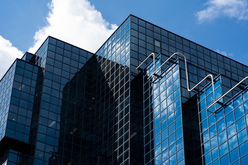 Free Architectural shot of a modern glass skyscraper in London with reflections of clouds and sky. Stock Photo