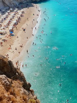 A stunning aerial view of Kaputaş Beach in Kaş, Turkey, showcasing clear turquoise waters and vibrant summer activity.