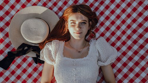 A Woman Lying Down on Checkered Picnic Blanket