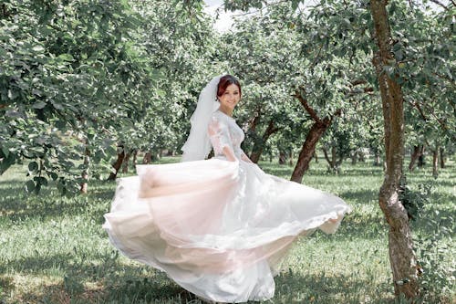 Woman Wearing A Wedding Gown Posing In A Tree Plantation