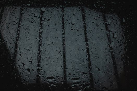 Close-up of rain droplets on a windowpane, creating a moody atmosphere.