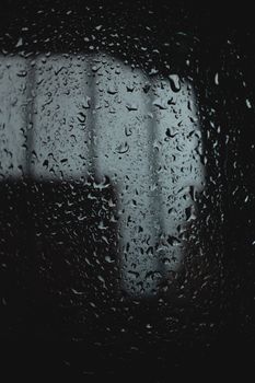 Close-up of raindrops on a window, capturing a moody and atmospheric vibe.