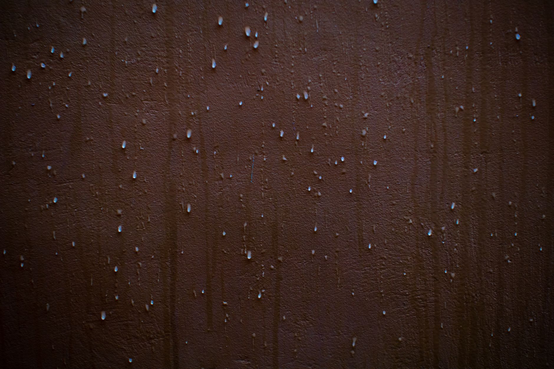 Water droplets on a brown masonry wall — chimney water infiltration and leak sources