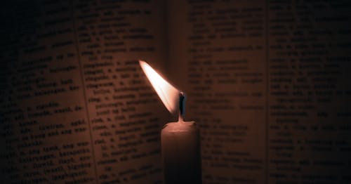 Burning Candle and an Open Book 