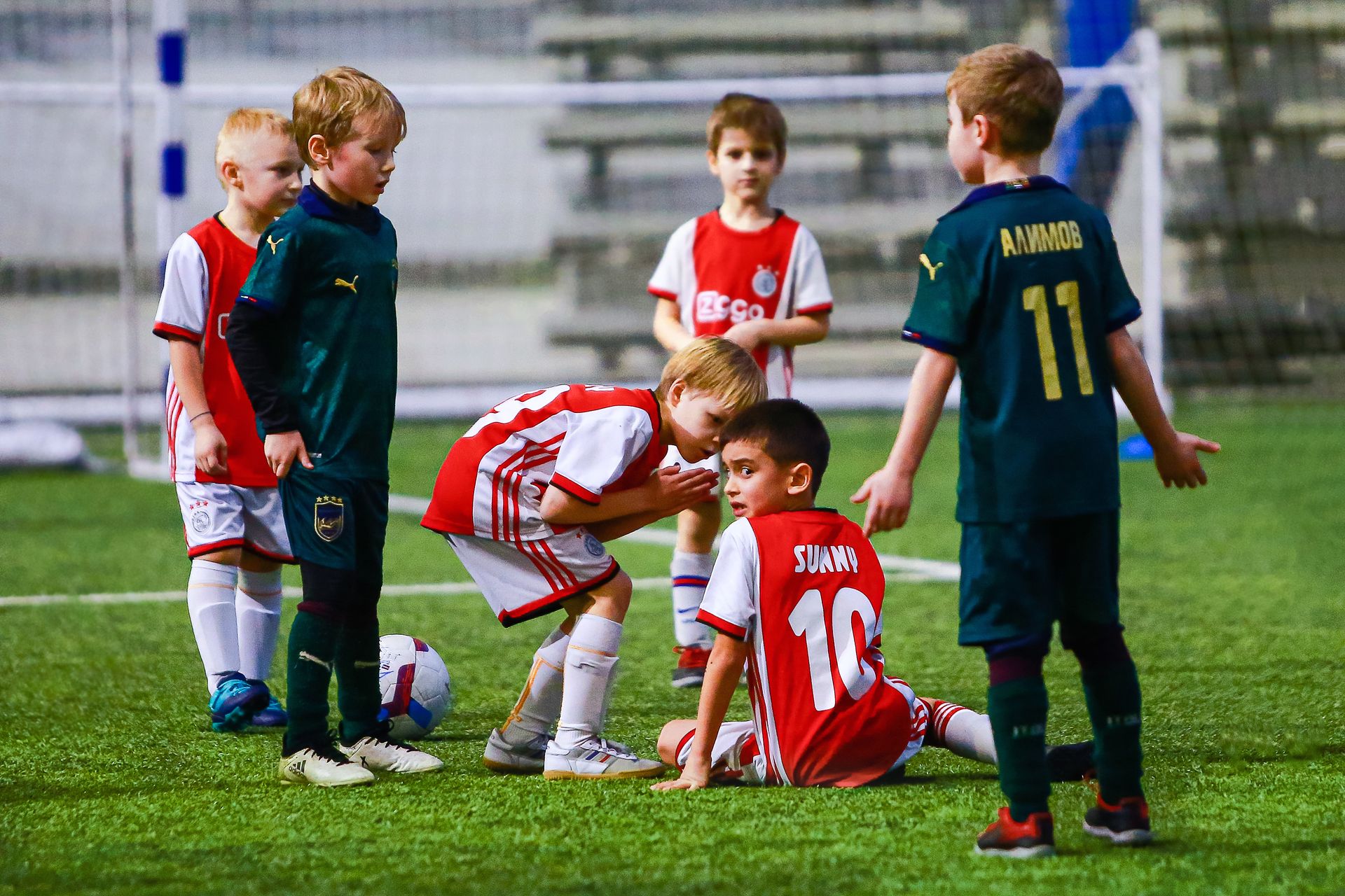 Kids engaged in a soccer game on an indoor field, showcasing teamwork.