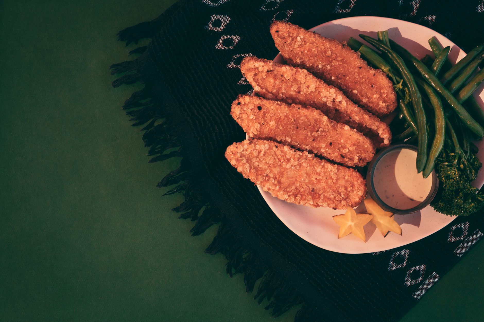Golden fried green beans cooling on a rack