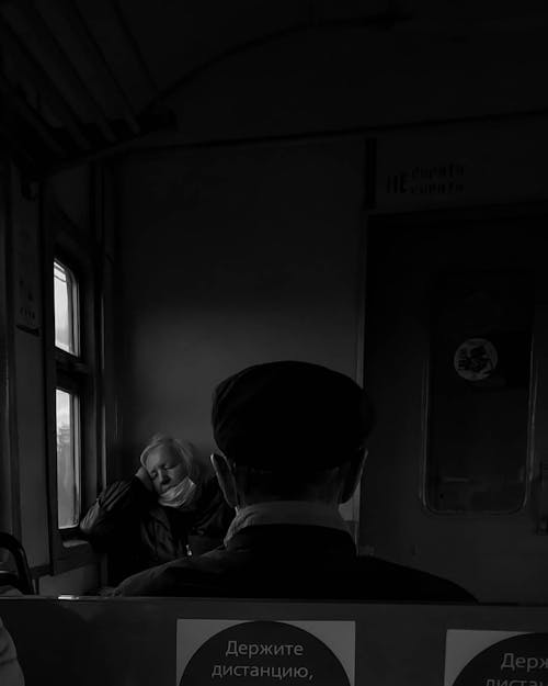 Grayscale Photo of a Person Wearing a Hat