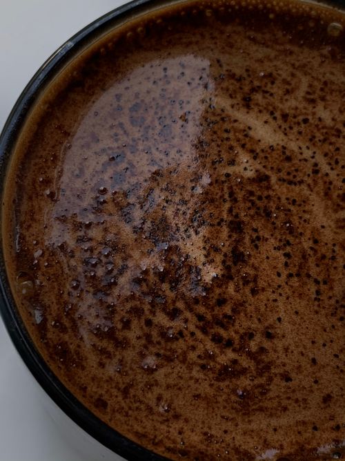 Free Detailed close-up of frothy coffee, capturing texture and color in an overhead view. Stock Photo
