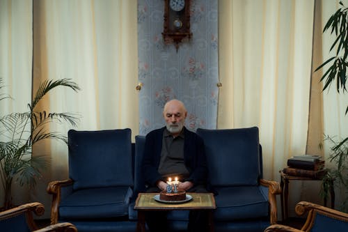 Elderly Man Looking at his Birthday Cake 