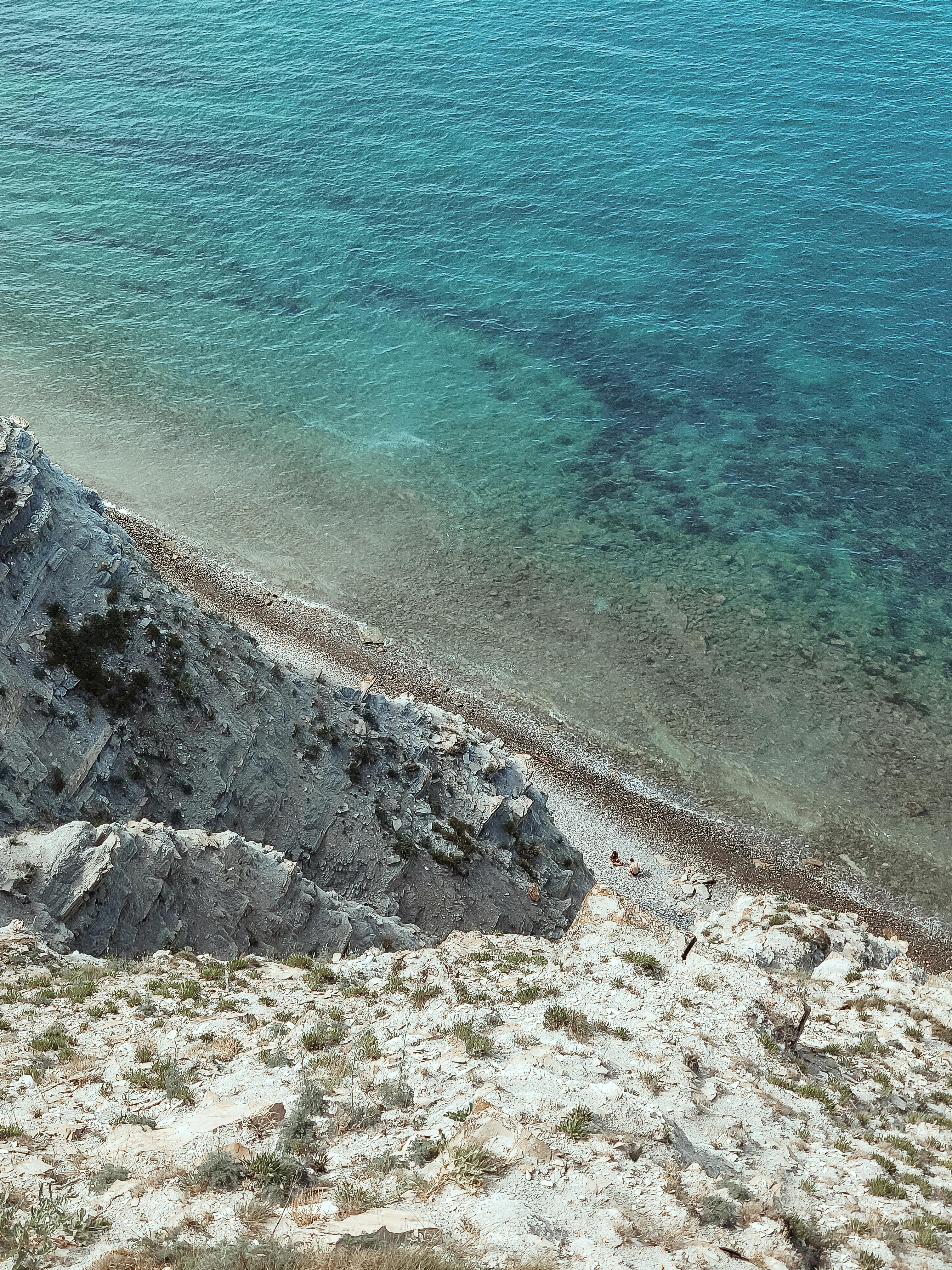 A striking aerial view of a rocky shore meeting the clear blue waters in Су-Псех, Краснодарский край, Россия.