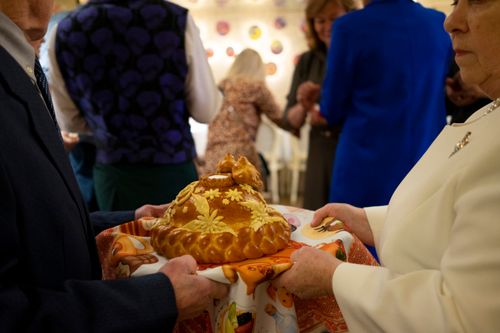 Free A traditional celebration featuring a beautifully decorated bread being held by participants. Stock Photo