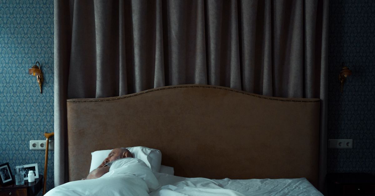 person sleeping with blackout curtains and white noise machine