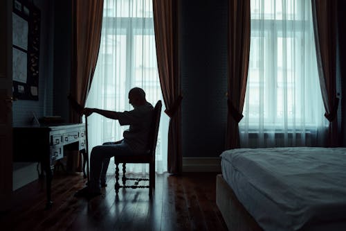 Free An Elderly Man Sitting on a Chair Stock Photo