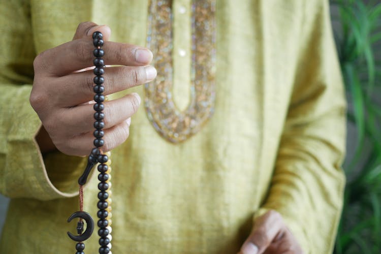 Hand Of Muslim Person Praying Using Prayer Beads