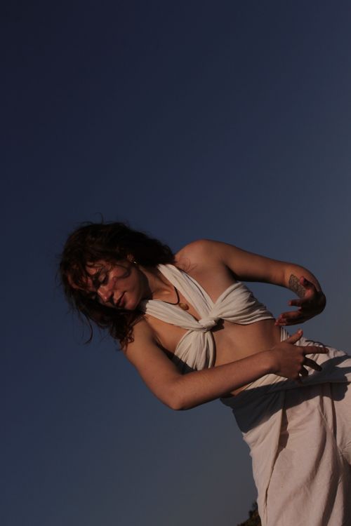Free A young woman gracefully dances outdoors in South Africa, expressing joy under a clear blue sky. Stock Photo