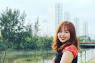 一位穿着传统服装的快乐女人在公园里微笑，公园靠近城市建筑