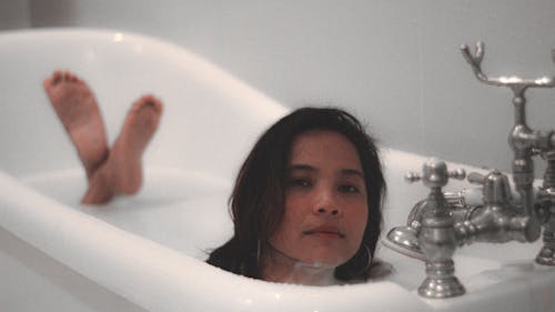 A Woman in White Bathtub With Water