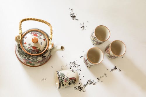 Set of Oriental Teapot and Tea Cups on White Surface