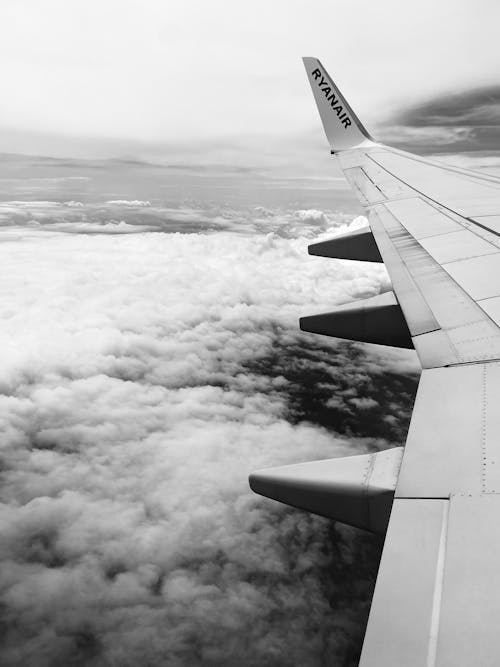 Free Grayscale Photo of Airplane Wing Above Clouds Stock Photo