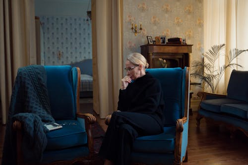 Elderly Woman Sitting on a Blue Armchair