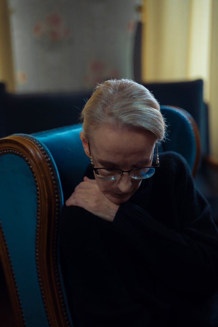 An Elderly Woman In Black Sweater Looking Down