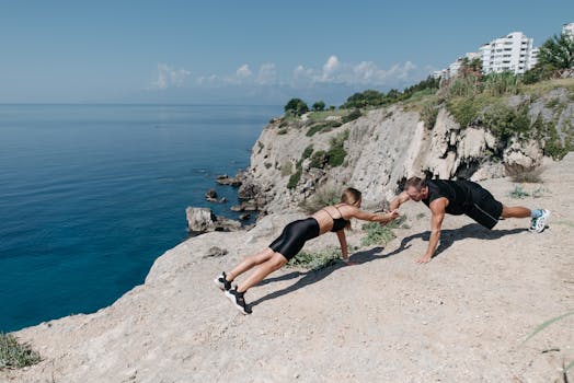 Fitness couple engaging in outdoor exercise on scenic seaside cliffs, promoting active lifestyle.