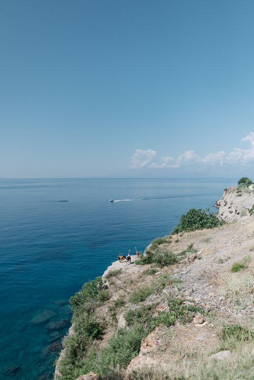 Free Breathtaking aerial view of a cliff overlooking a vast blue ocean under a clear sky. Stock Photo