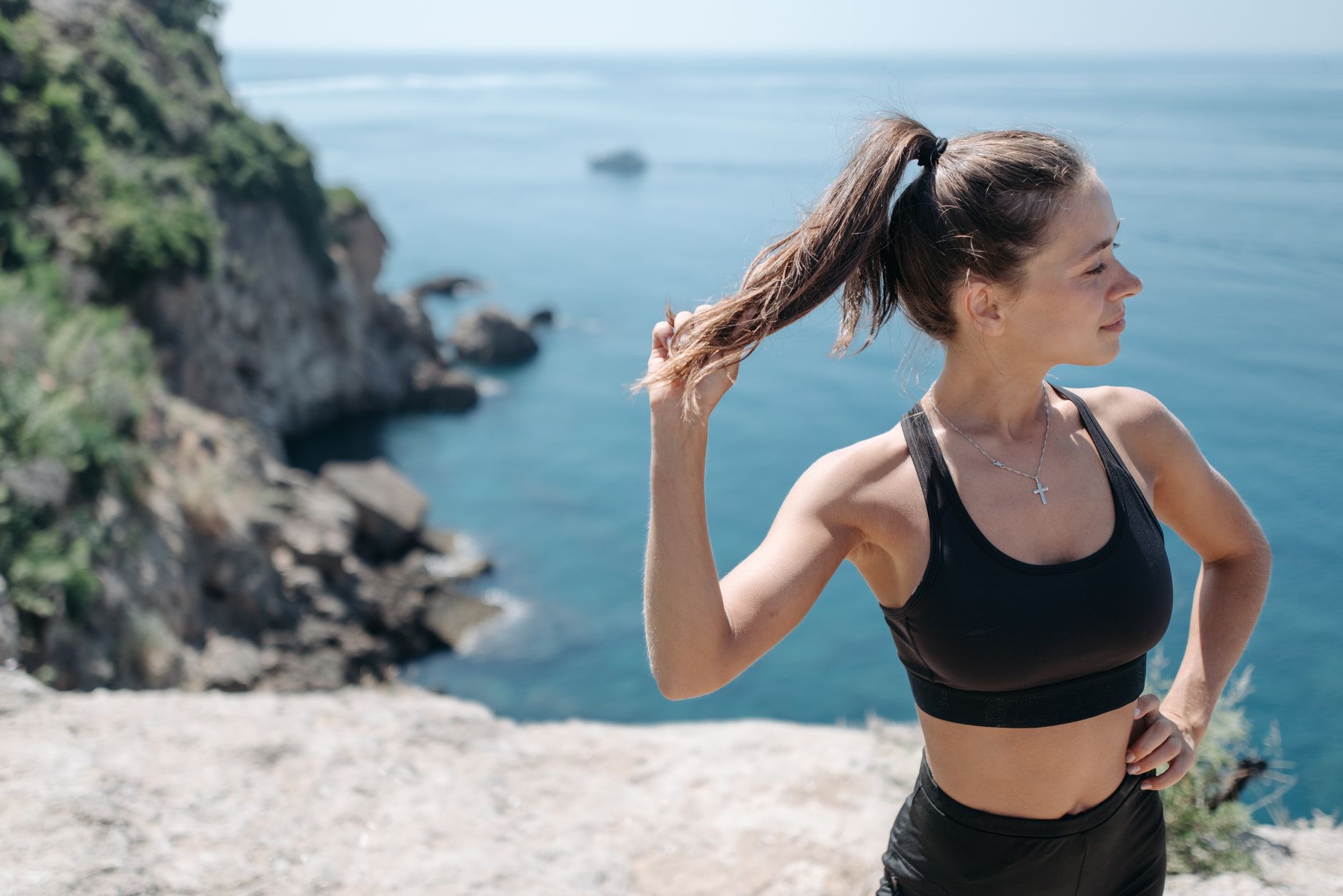 Fit woman in activewear enjoying workout by the sea. Perfect for lifestyle and fitness themes.