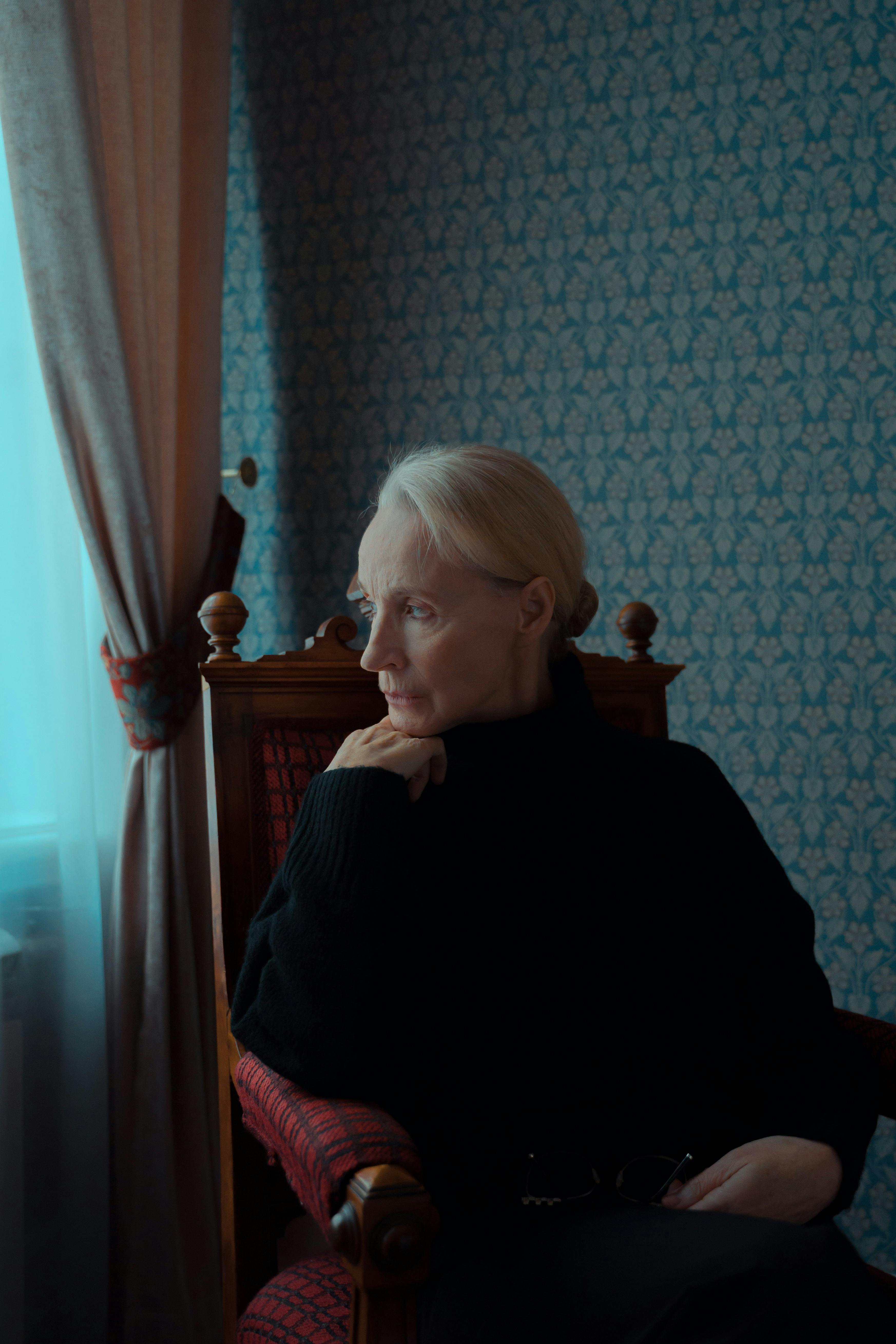 woman in black sweater sitting on a wooden chair