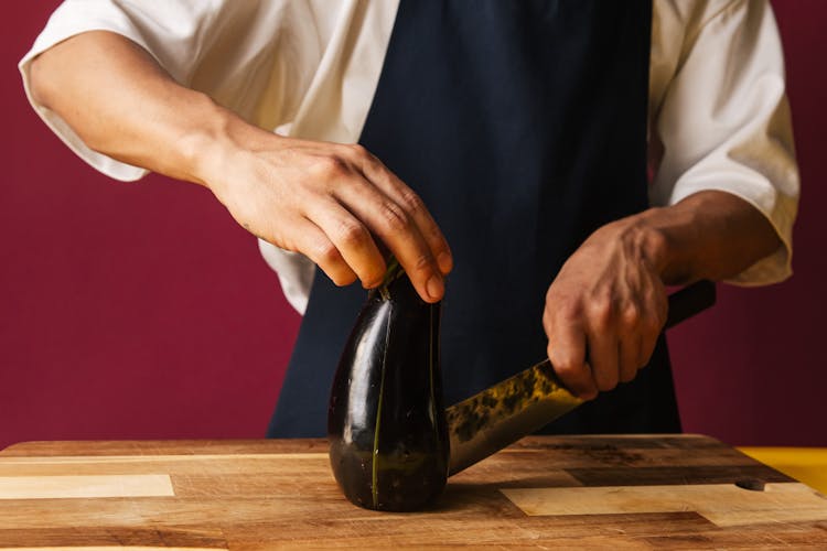 Person Cutting An Eggplant