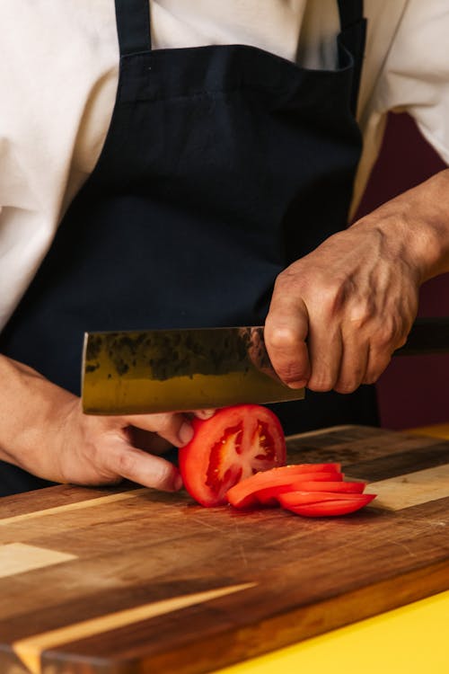 Person Slicing Tomatoes