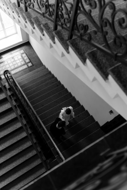 High angle view of two people descending a staircase, monochrome style.