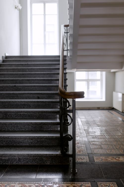 Free A classic indoor staircase featuring ornate iron handrail and tiled floor. Stock Photo
