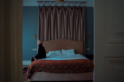 A Woman Sitting Alone on Her Bed