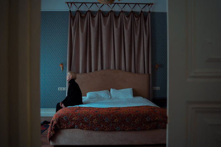 A Woman Sitting Alone On Her Bed