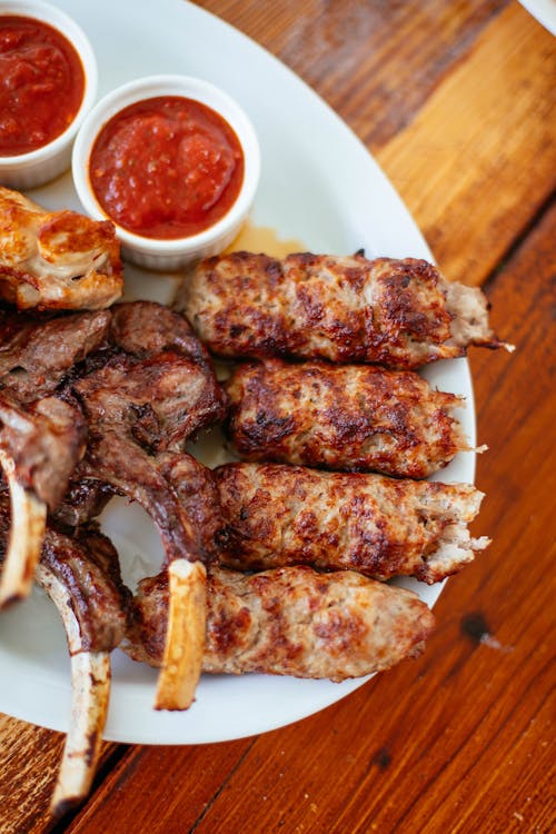 Free Barbecued Meat with Sauce on White Ceramic Plate Stock Photo