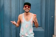 巴黎有个快乐的男人，正靠在蓝色门上吃着冰淇淋，充满了时尚而有趣的夏日氛围