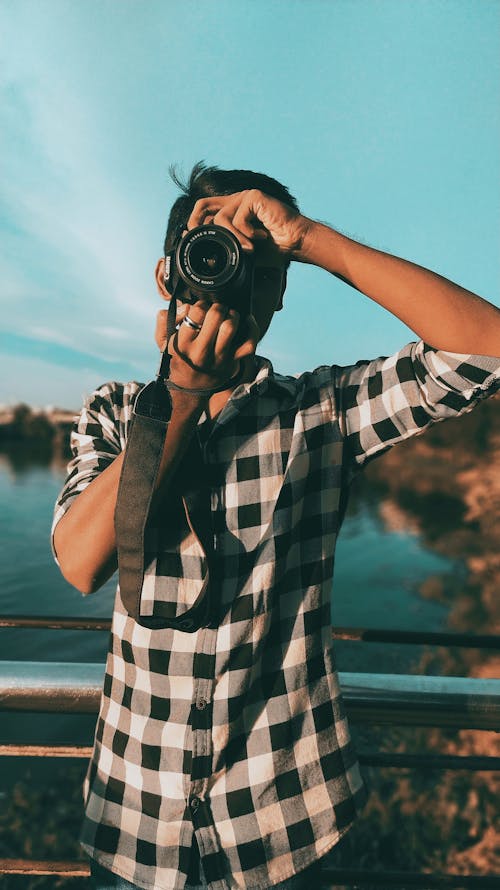 A Photographer Wearing a Checkered Long Sleeves Polo Shirt